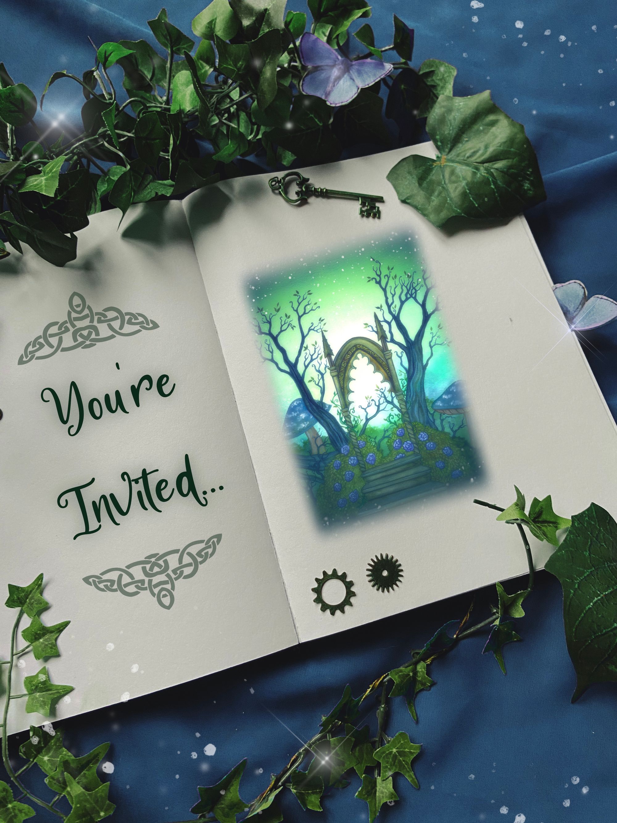A book covered in ivy and sparkles open to a page with the words 'you're invited' and a painting of a magic portal